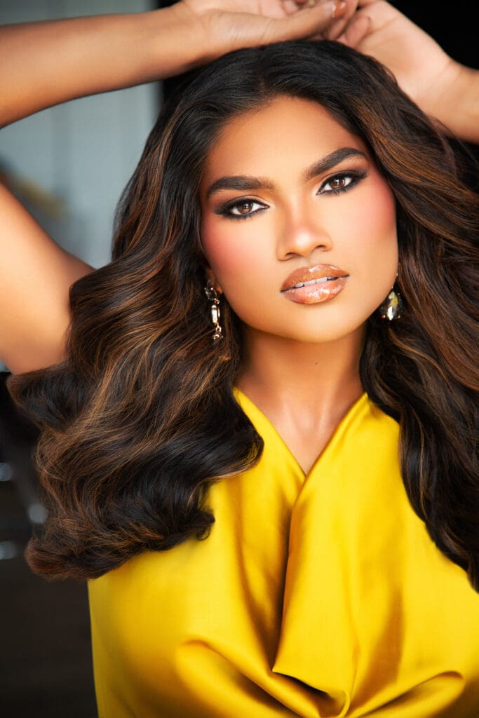 pageant headshot with arms above head and neutral facial expression